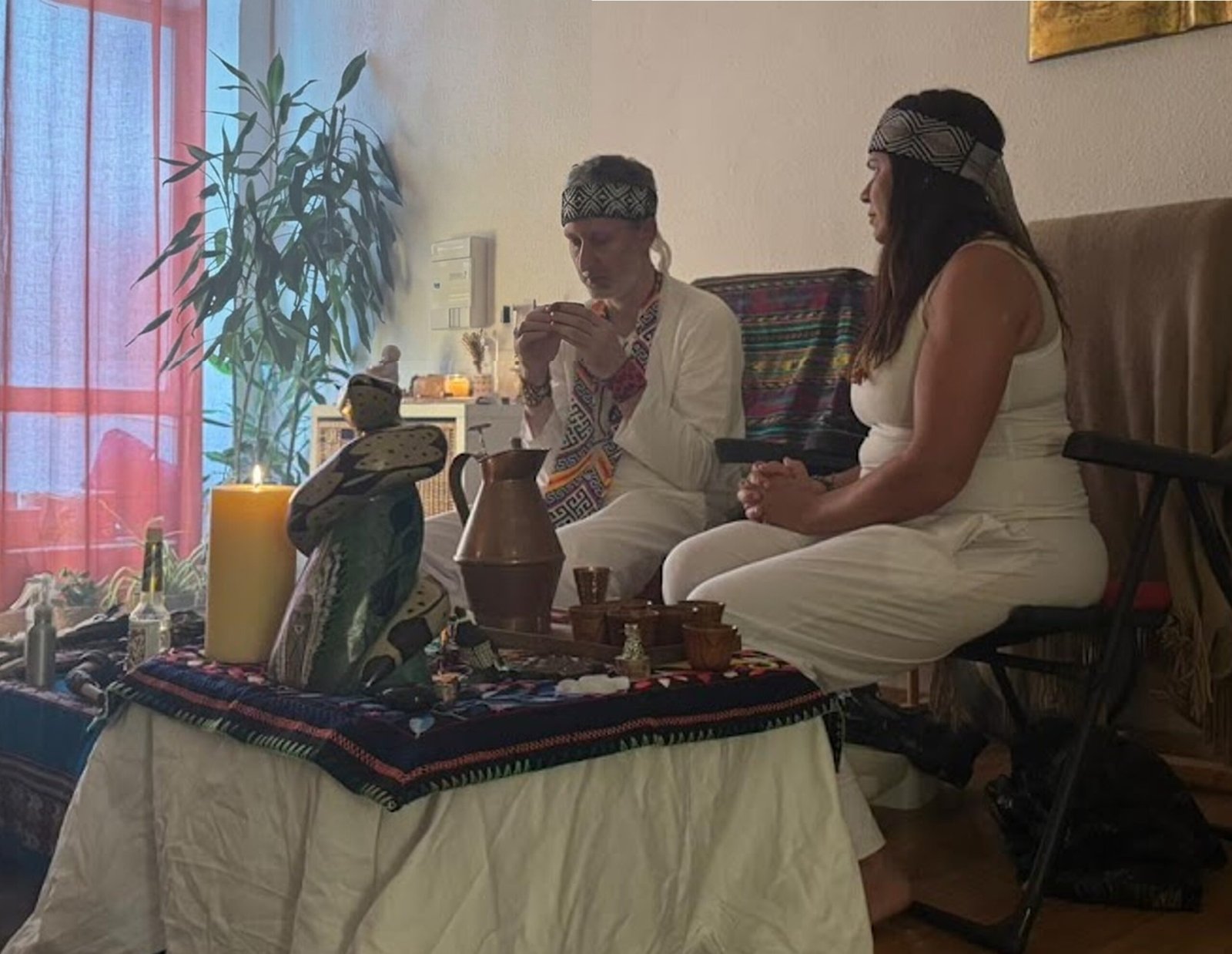 Fede Funkel y una cofacilitadora sentados junto al altar antes de una ceremonia
